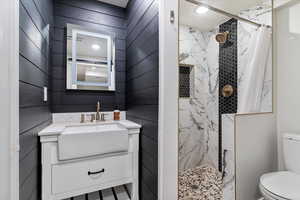 Full bathroom featuring a marble finish shower, vanity, and a textured ceiling