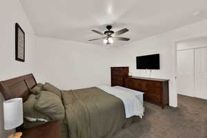 Carpeted bedroom featuring a ceiling fan