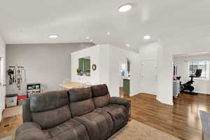 Living area with wood finished floors, arched walkways, and recessed lighting