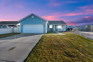 Ranch-style home featuring concrete driveway, a porch, and a garage