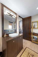 Bathroom with vanity, tasteful backsplash, and light colored carpet