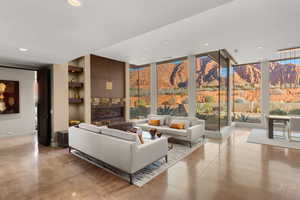 Living room featuring concrete floors, a mountain view, built in shelves, recessed lighting, and floor to ceiling windows