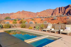View of pool with a mountain view, a patio area, a fenced backyard, and an in-ground hot tub