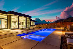 View of swimming pool featuring a patio area, a fenced backyard, and a pool with connected hot tub