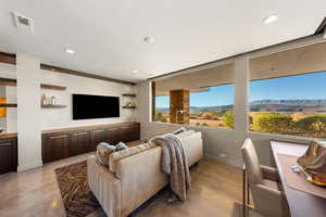 Living area with finished concrete flooring and recessed lighting