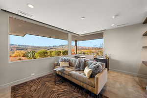 Sitting room with a mountain view, finished concrete floors, and recessed lighting