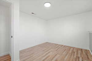 Empty room with light wood-style floors and baseboards