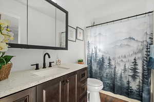 Full bathroom featuring vanity and curtained shower