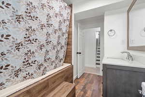 Bathroom featuring vanity, a shower with shower curtain, and dark wood-style floors