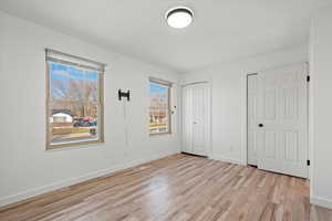 Unfurnished bedroom featuring two closets and light wood-type flooring