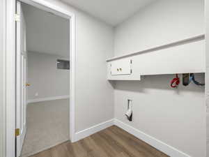 Washroom with baseboards and light wood finished floors