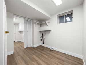 Laundry area with wood finished floors, hookup for a gas dryer, and hookup for a washing machine