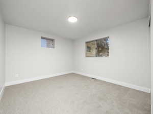 Unfurnished room featuring light colored carpet and baseboards