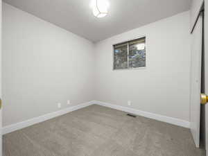 Unfurnished bedroom with light carpet and a closet