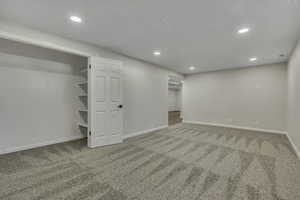 Basement with recessed lighting and light colored carpet