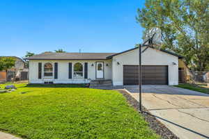 View of front of property featuring concrete driveway, brick siding, an attached garage, and a gate