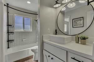 Full bathroom featuring washtub / shower combination, vanity, and light wood-type flooring