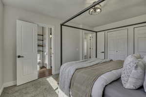 Carpeted bedroom featuring a closet and baseboards