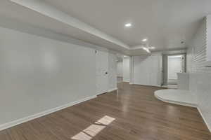 Unfurnished room featuring recessed lighting, wood finished floors, and brick wall