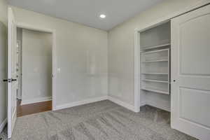 Unfurnished bedroom with light carpet, a closet, and recessed lighting