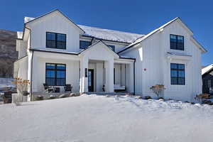 View of front of property with board and batten siding and a porch