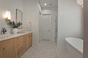 Full bathroom with a freestanding bath, a stall shower, vanity, light floors, and recessed lighting