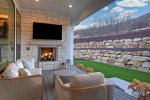 View of patio with a deck and an outdoor living space with a fireplace