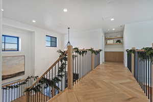 Hallway featuring recessed lighting and an upstairs landing