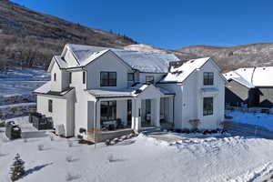 Modern farmhouse style home with a porch, a mountain view, board and batten siding, and a metal roof
