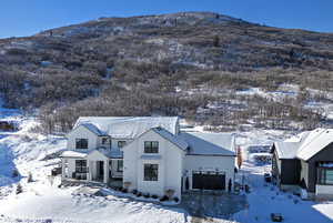 View of front of home with a mountain view and an attached garage