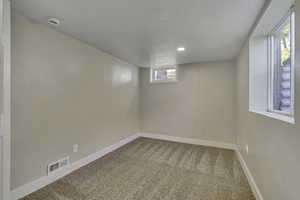 Unfurnished room with carpet floors and a smoke detector