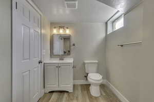 Bathroom with vanity, light wood-style flooring, and a textured ceiling
