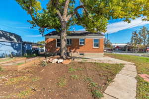 Rear view of house featuring brick siding and a garden