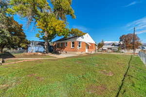 View of property exterior with a fenced backyard and brick siding