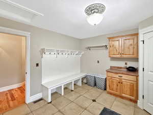 Mudroom featuring light tile patterned floors and a textured ceiling