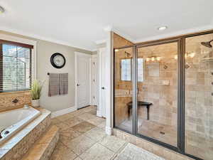 Bathroom featuring a garden tub, a shower stall, crown molding, and plenty of natural light