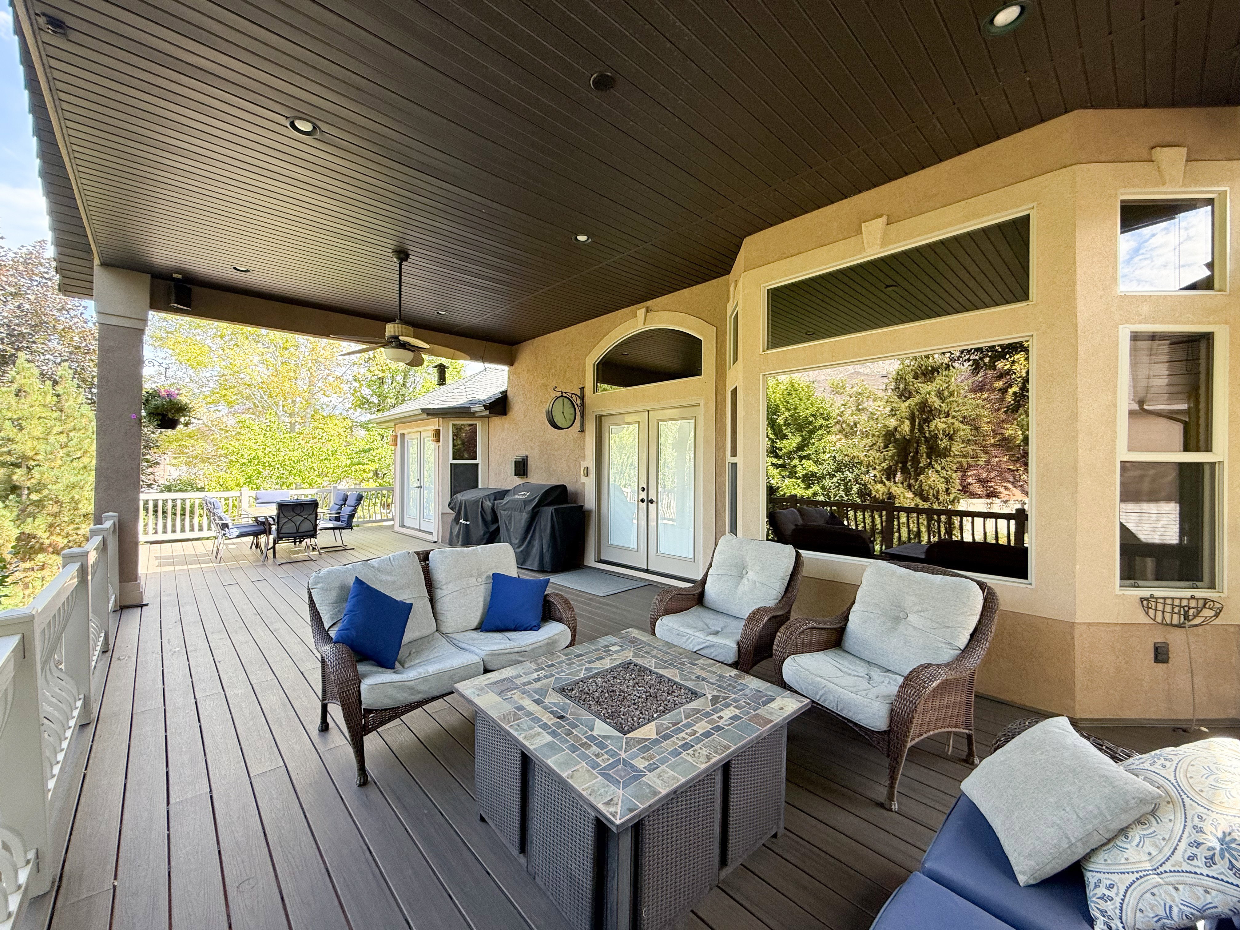Deck featuring an outdoor living space with a fire pit, outdoor dining space, area for grilling, and french doors