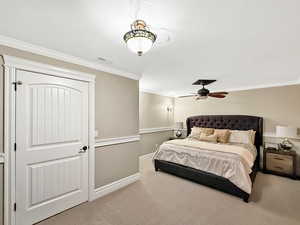 Carpeted bedroom with ornamental molding, a textured ceiling, and ceiling fan