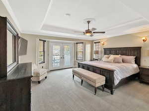 Bedroom featuring french doors, a raised ceiling, carpet floors, access to outside, and ceiling fan