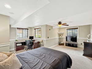 Bedroom featuring an office area, carpet floors, a ceiling fan, and a textured ceiling