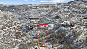 Snowy aerial view featuring property boundaries highlighted and a mountain view
