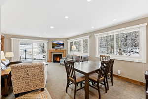 Dining area featuring a fireplace with flush hearth, light carpet, and recessed lighting