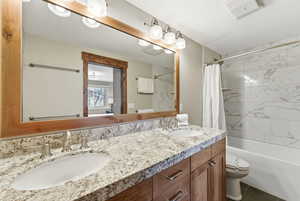 Bathroom featuring shower / tub combo with curtain and double vanity