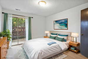 Bedroom featuring access to exterior and wood finished floors