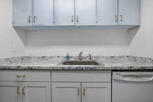 Kitchen with dishwasher and light stone counters