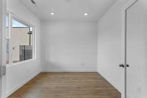 Empty room with wood finished floors and recessed lighting