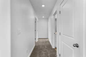 Hallway featuring light carpet, recessed lighting, and attic access