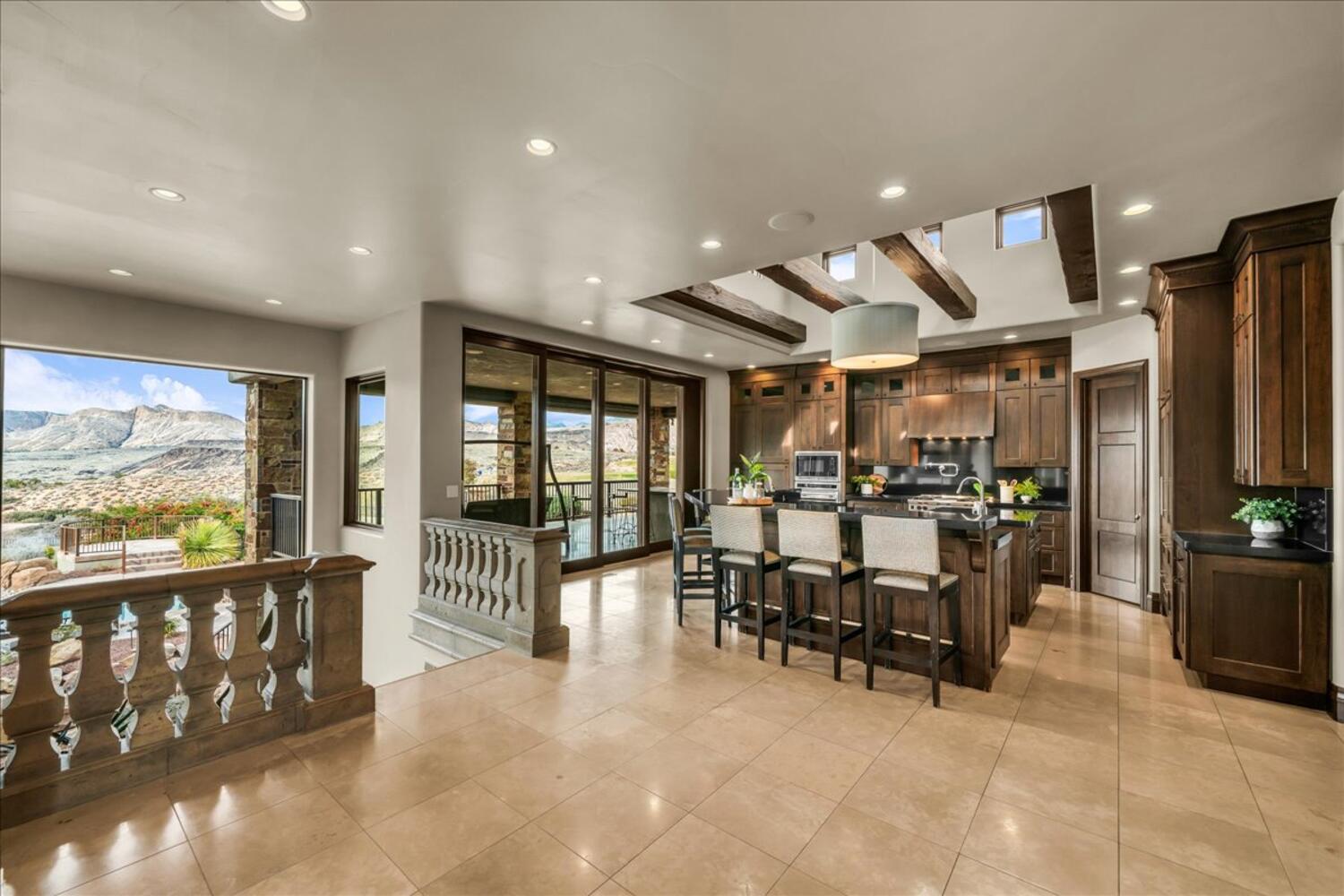Kitchen with glass insert cabinets, a kitchen breakfast bar, an island with sink, recessed lighting, and a mountain view