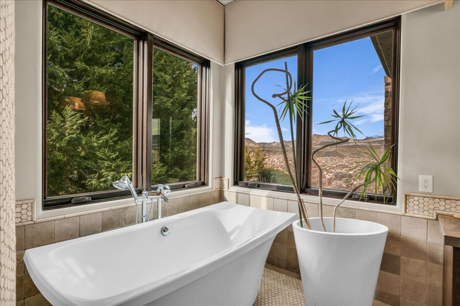Bathroom with tile walls, a soaking tub, wainscoting, and tile patterned flooring