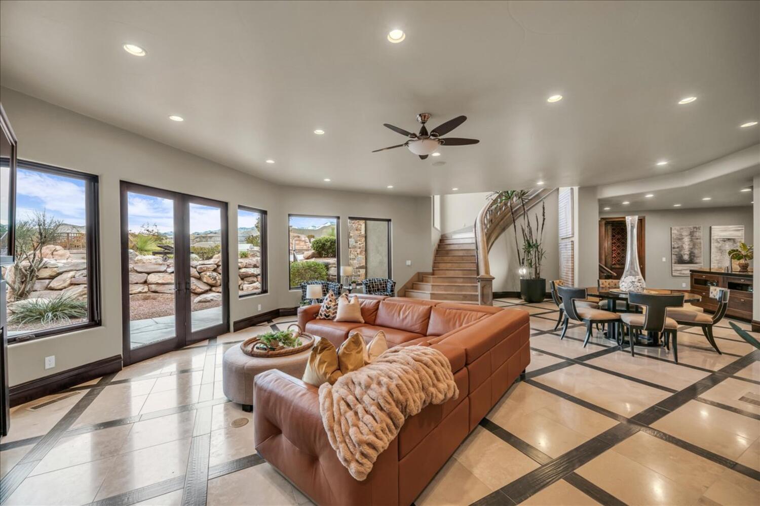 Living area featuring inlaid floor details, recessed lighting, a ceiling fan, stairs, and french doors